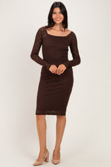 woman wearing a brown long sleeve fitted lace dress with a square neckline and mid-length hemline