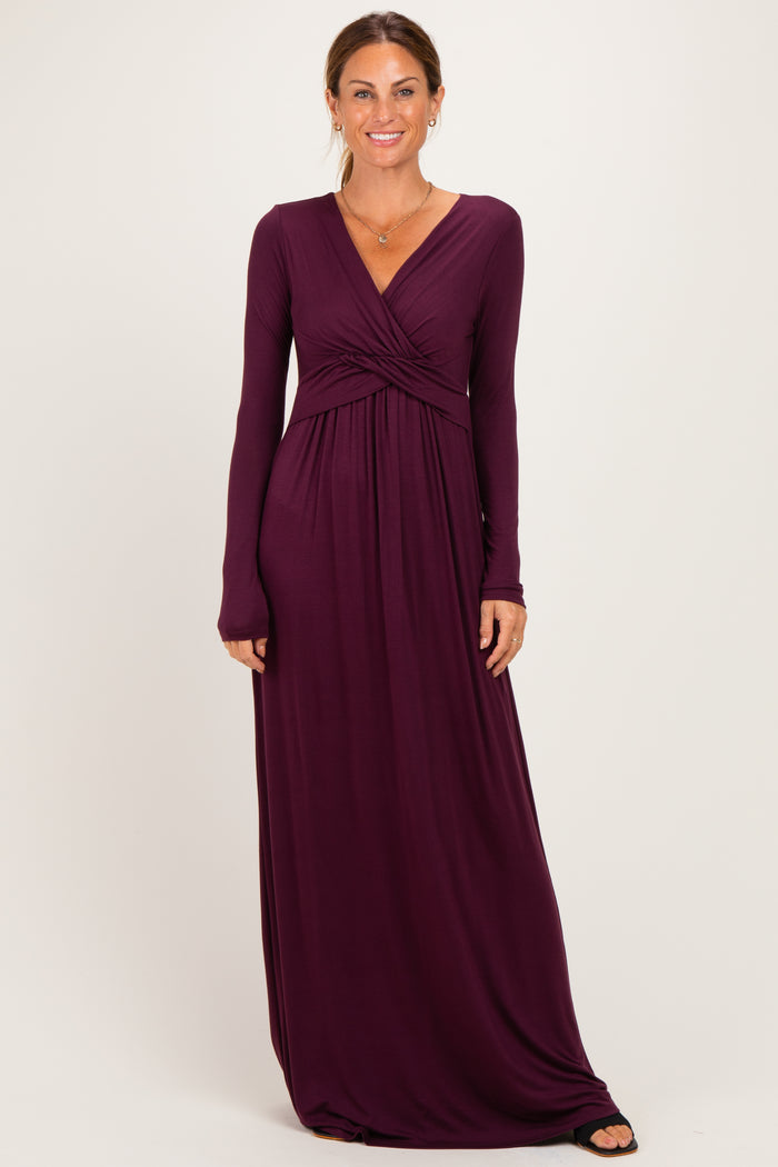 woman wearing a burgundy long sleeve maxi dress with a twisted front detailing and a flowing silhouette