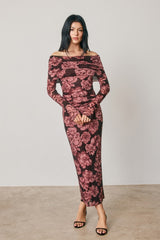 woman wearing a burgundy off-the-shoulder floral midi dress with long sleeves and a fitted silhouette