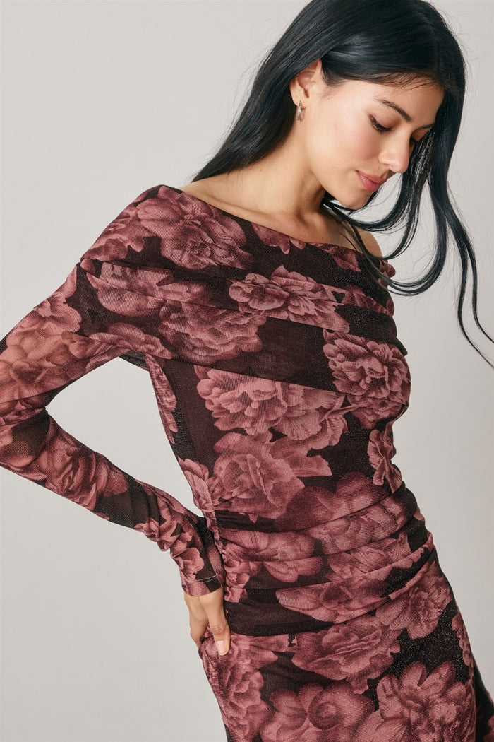 woman wearing a long sleeve off-the-shoulder floral bodycon dress in burgundy and black hues