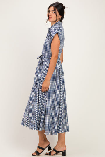 woman wearing a navy blue gingham midi dress with short sleeves and a tie waist detail