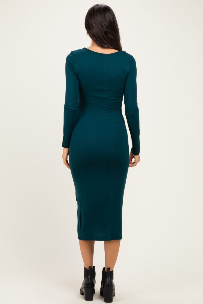 woman wearing a fitted teal long sleeve midi dress, viewed from the back, paired with black ankle boots