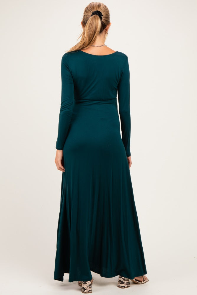 woman wearing a long sleeve teal maternity maxi dress, showing a flowing silhouette from the back