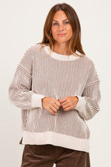 woman wearing a beige and brown striped oversized sweater with long sleeves and a relaxed fit