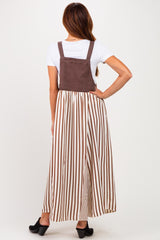woman wearing a brown and white striped maxi dress with a solid brown bodice and a flowy skirt