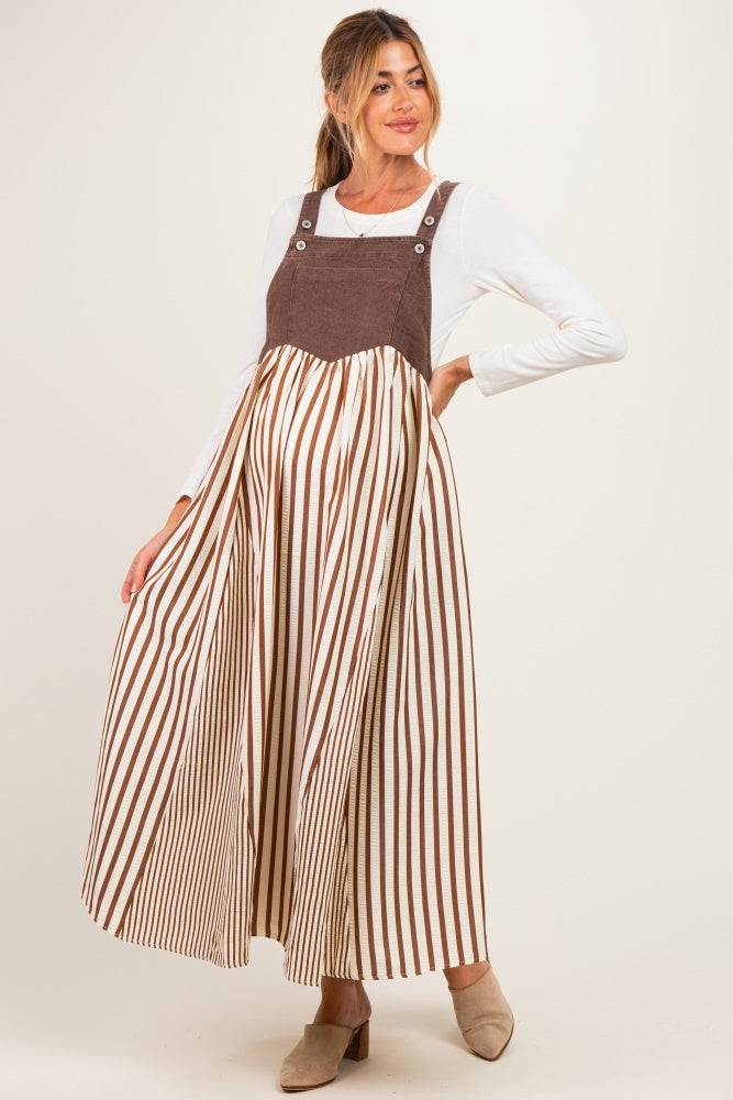 woman wearing a brown and white striped maternity maxi dress with a fitted bodice and loose skirt, showing off her baby bump