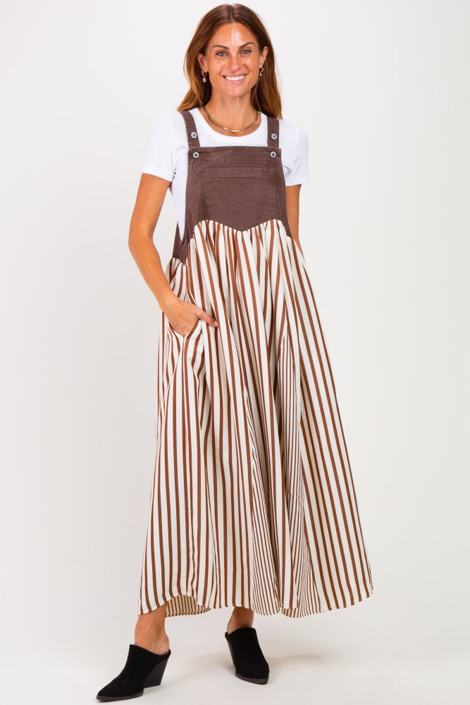 woman wearing a brown and white striped maxi dress with adjustable straps and a solid top underneath