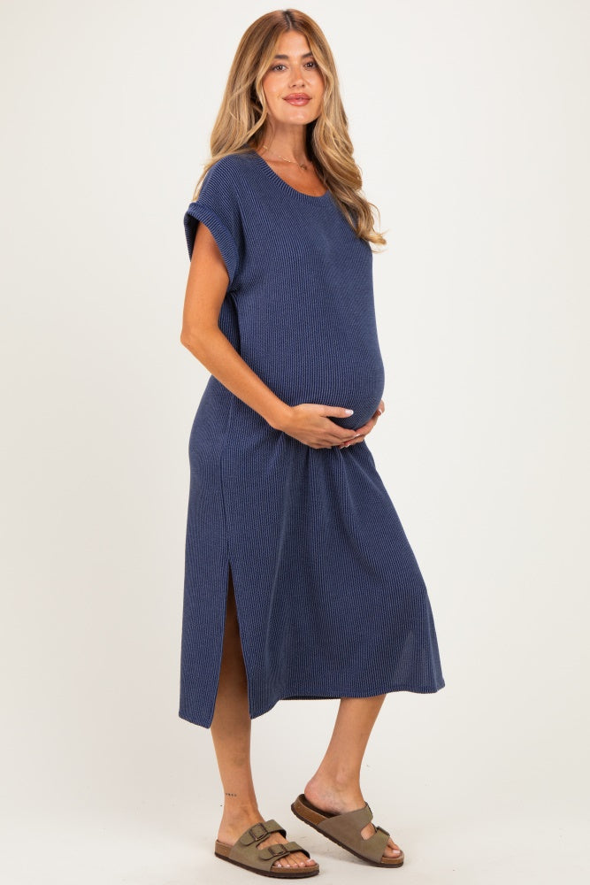 woman wearing a navy blue striped maternity dress with side slits and holding her baby bump