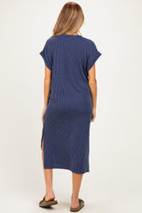woman wearing a navy blue ribbed maternity maxi dress with side slits and short rolled sleeves, showing a baby bump