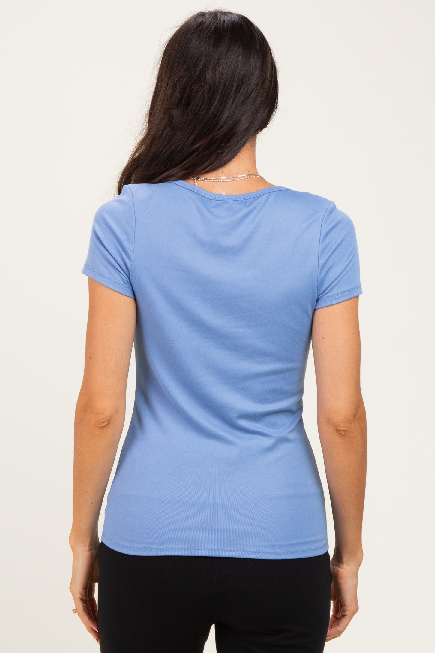 woman wearing a light blue short sleeve fitted top viewed from the back