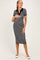 woman wearing a black and white striped maternity dress with a polo collar and holding her baby bump