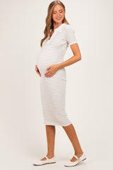 woman wearing a striped maternity dress with short sleeves and a collar, cradling her baby bump