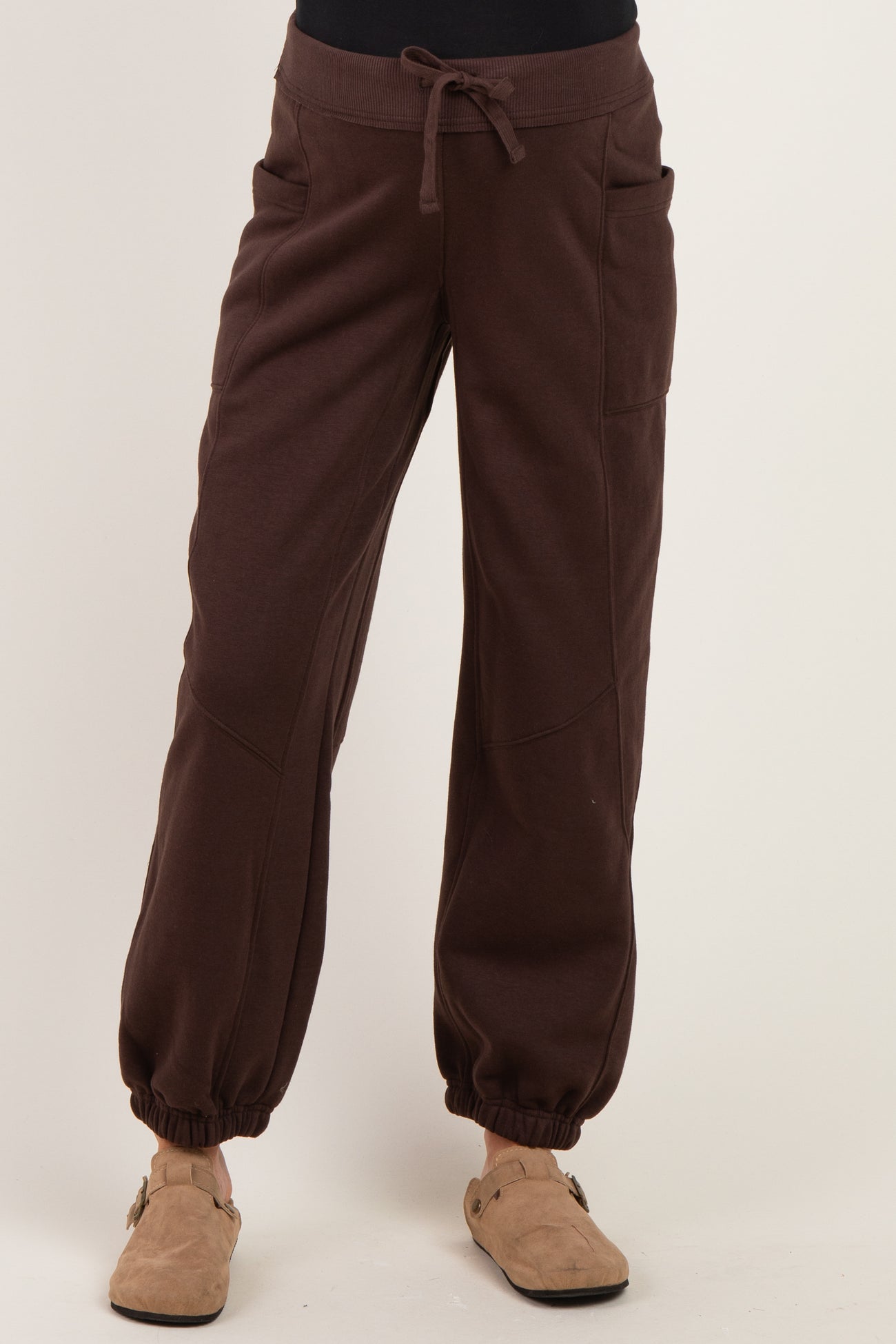 woman wearing dark brown maternity jogger pants with elastic cuffs and pockets