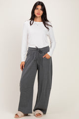 woman wearing a white long sleeve ribbed top and gray wide leg lounge pants with a drawstring waist