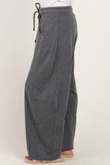 woman wearing dark gray wide-leg sweatpants with a drawstring waist and side pockets