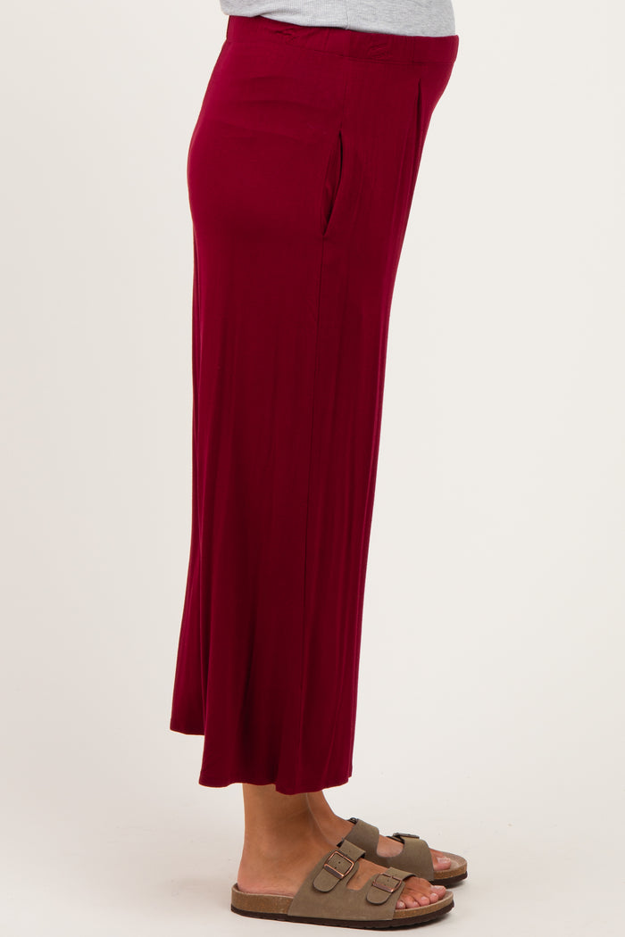 woman wearing a burgundy maternity maxi skirt with side slits and comfortable sandals
