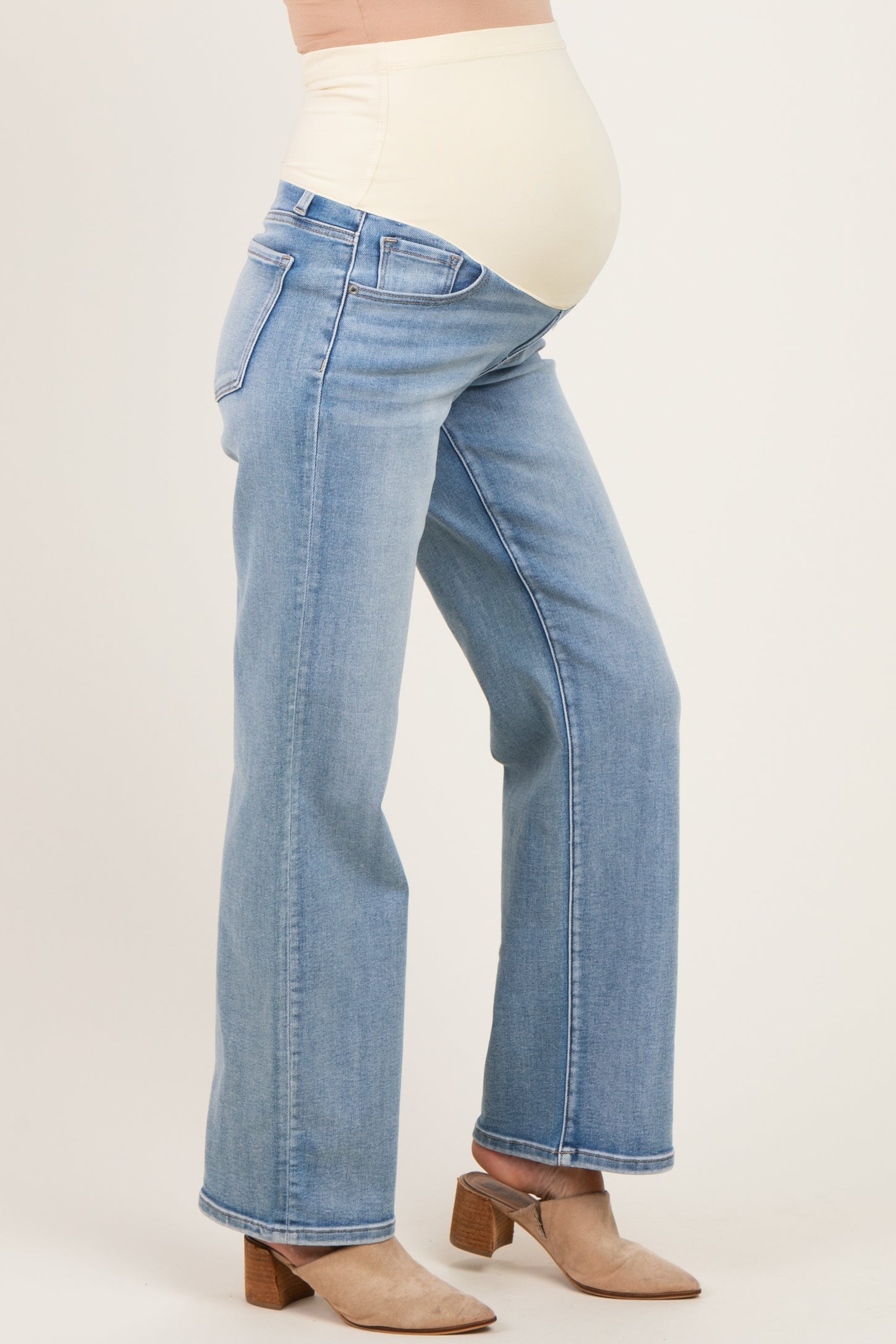 woman wearing light blue maternity jeans with a supportive over-the-bump waistband and a visible baby bump