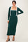 woman wearing a dark green ribbed maxi dress with a white trimmed open cardigan and strappy black heels