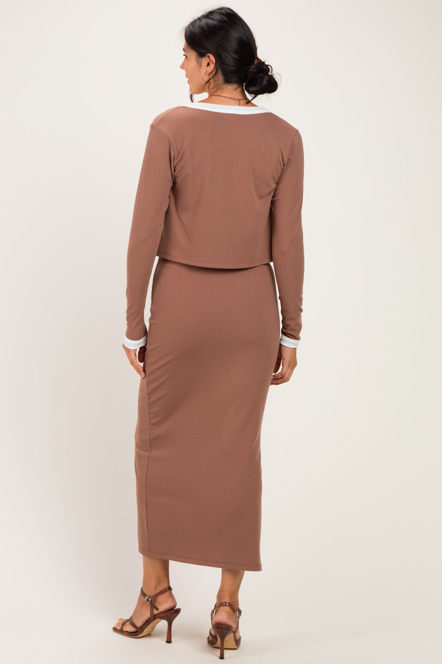 woman wearing a brown ribbed two-piece set with a cropped long sleeve top and a matching midi skirt