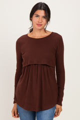 woman wearing a brown long sleeve ribbed top with a gathered waist, paired with blue jeans