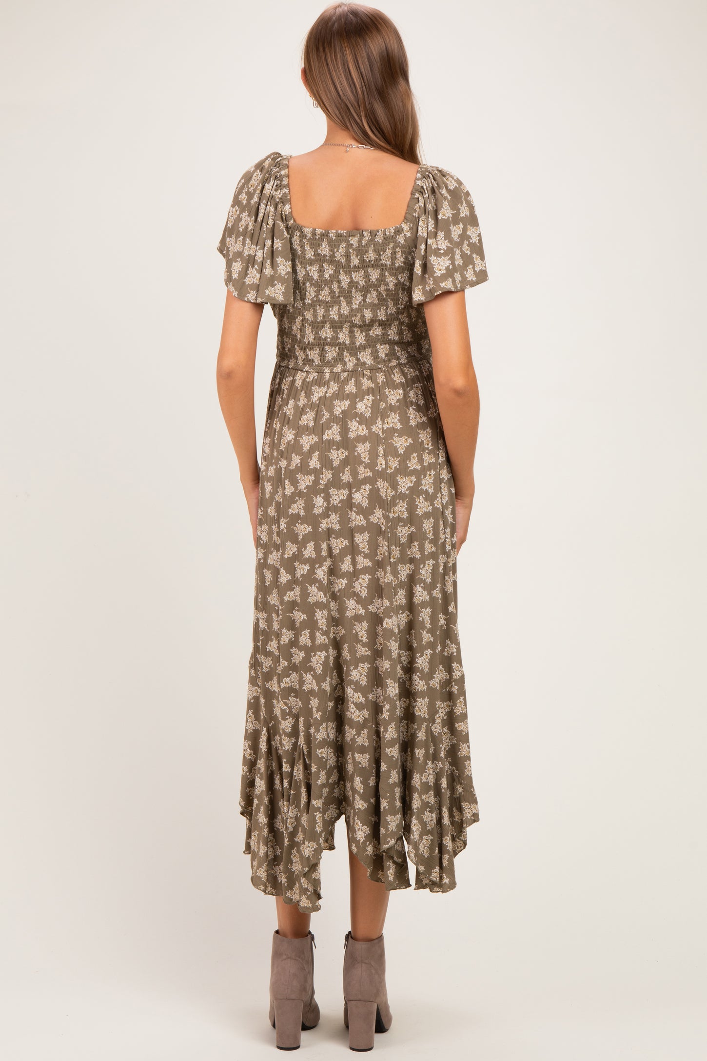 woman wearing a brown floral print maternity dress with short puff sleeves and a ruffled hem