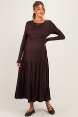 woman wearing a dark brown long sleeve maternity dress with tiered skirt and visible baby bump