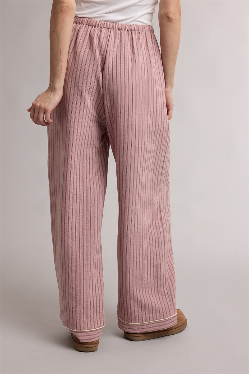 woman wearing loose-fitting pink striped wide-leg pants with an elastic waistband