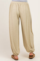 woman wearing beige striped maternity harem pants with an elastic waistband and tapered cuffs