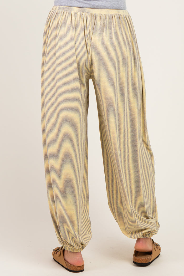 woman wearing beige striped maternity harem pants with an elastic waistband and tapered cuffs