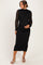 woman wearing a black lace maternity dress with long sleeves and a fitted silhouette, cradling her baby bump