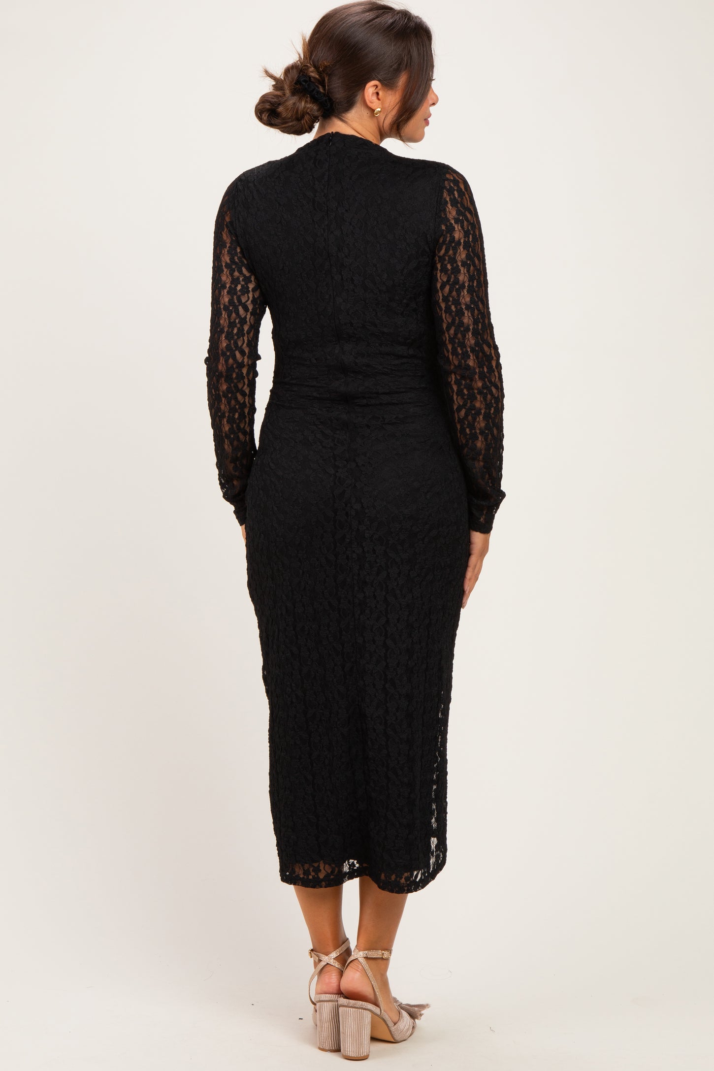 woman wearing a black lace maternity dress with long sleeves and a fitted silhouette, viewed from the back