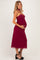 woman wearing a burgundy maternity dress with a fitted bodice and flowing skirt, showing her baby bump