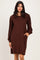 woman wearing a brown long sleeve ribbed dress with puffed sleeves and side pockets