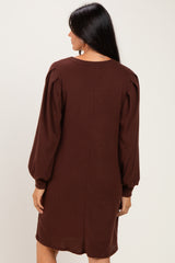 woman wearing a brown ribbed long sleeve dress with puffed sleeves, seen from the back