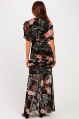 woman wearing a black floral ruched maxi dress with sheer skirt and short sleeves, shown from the back
