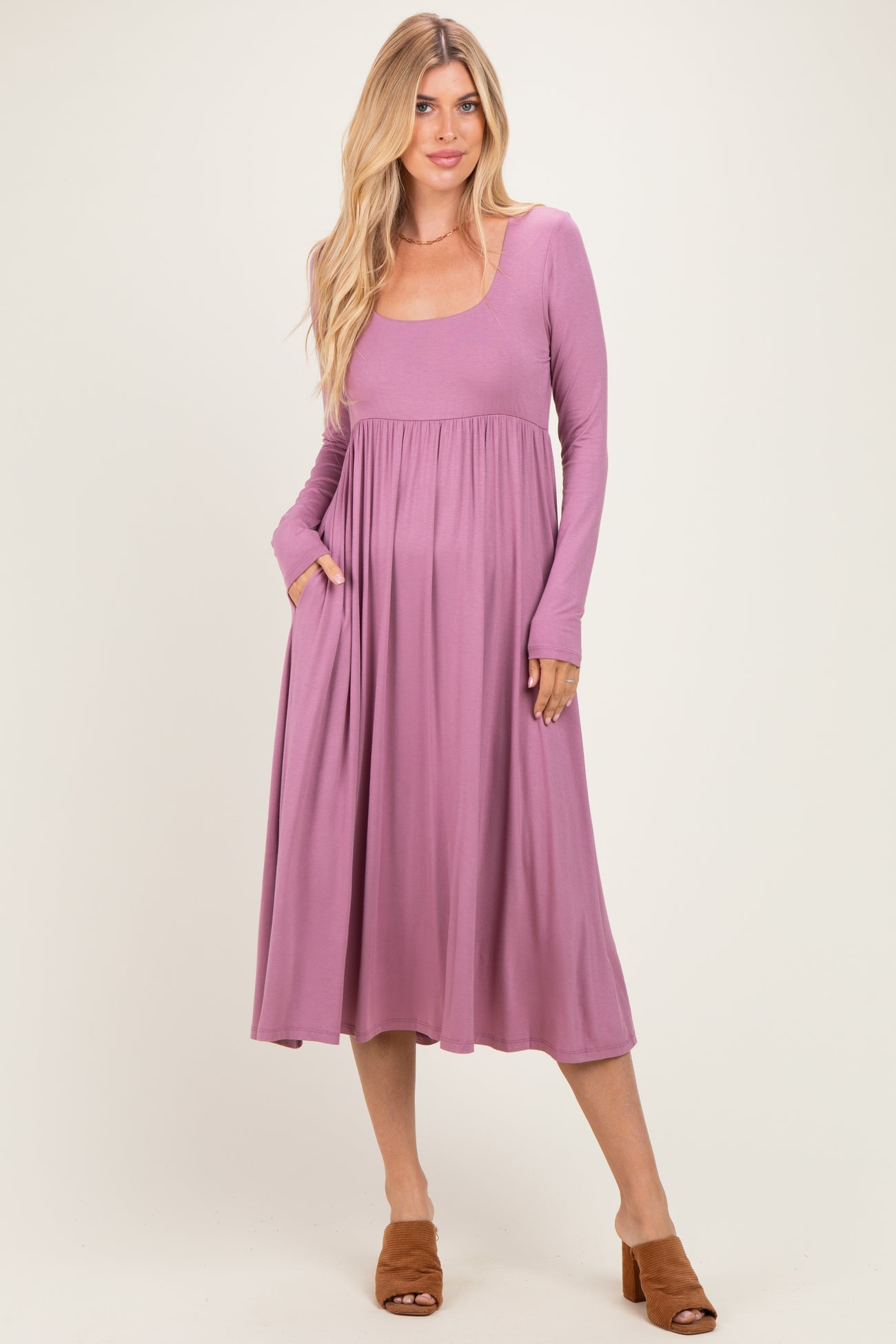woman wearing a long sleeve mauve maxi dress with pockets and a fitted bodice