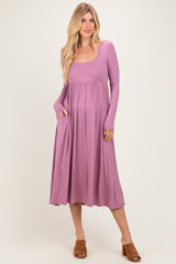 woman wearing a long sleeve mauve maxi dress with pockets and a fitted bodice