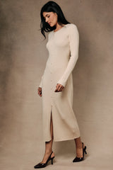woman wearing a beige ribbed button-up midi dress with long sleeves and a front slit