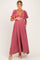 woman wearing a dusty rose maternity maxi dress with flutter sleeves and holding her baby bump