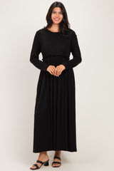 woman wearing a black long sleeve maxi dress with gathered waist detailing and relaxed fit