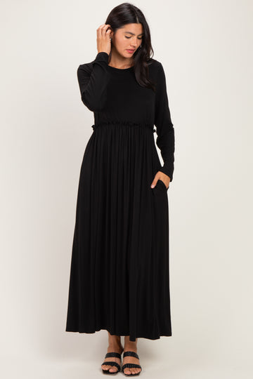 woman wearing a black long sleeve maxi dress with a cinched waist and pockets