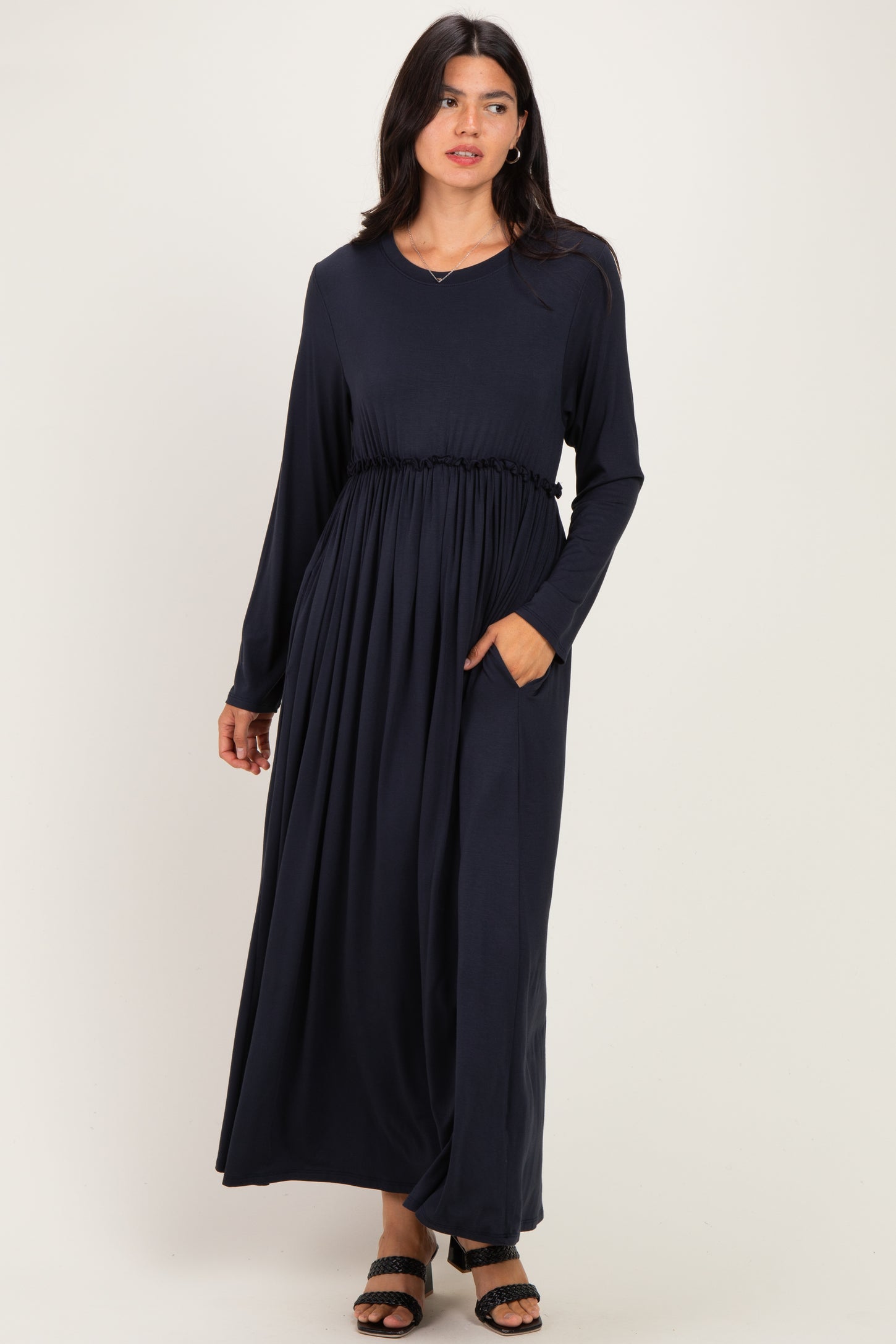 woman wearing a navy blue long sleeve maxi dress with a cinched waist and pockets