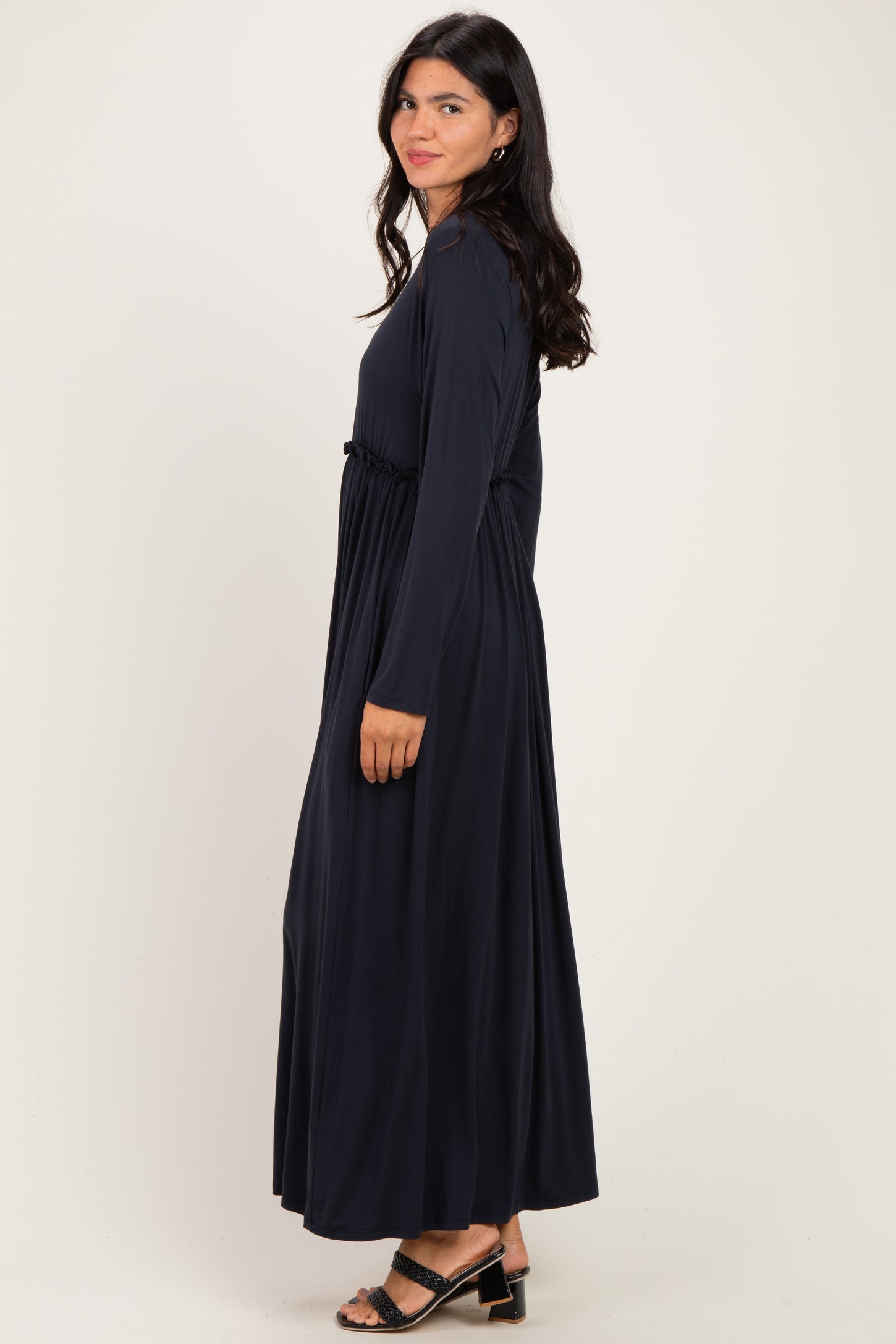 woman wearing a long sleeve navy blue maxi dress with an elastic waistband and side view pose