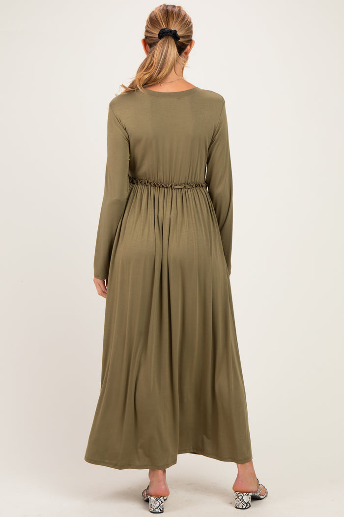 woman wearing an olive green long sleeve maternity maxi dress with an elastic waist from the back