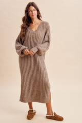 woman wearing a tan ribbed knitted long sleeve sweater dress and brown slippers