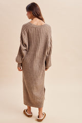 woman wearing a beige ribbed knit oversized sweater dress with long sleeves and a back scoop neckline