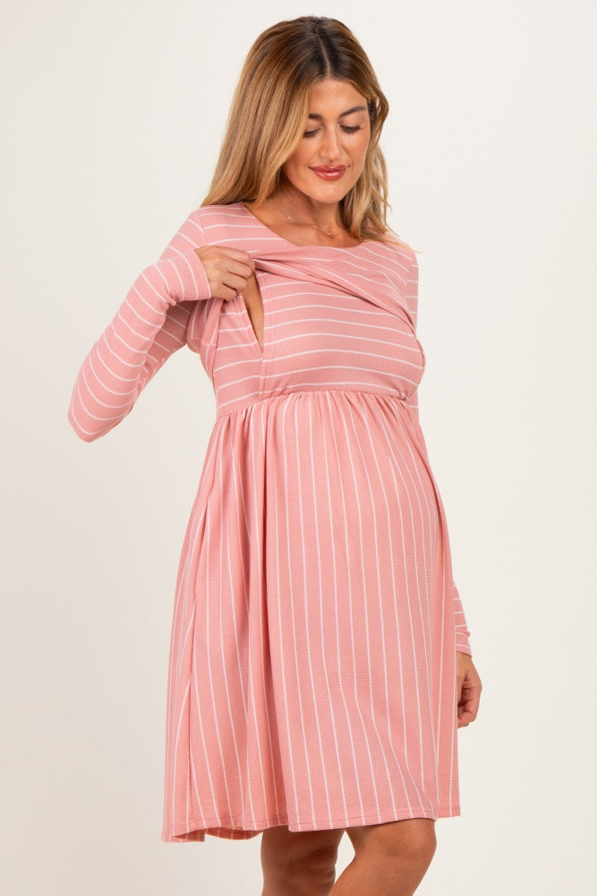 woman wearing a pink striped maternity dress with a crossover front and a visible baby bump