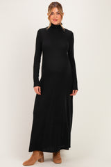 woman wearing a black long sleeve maternity maxi dress with a mock turtleneck and a visible baby bump