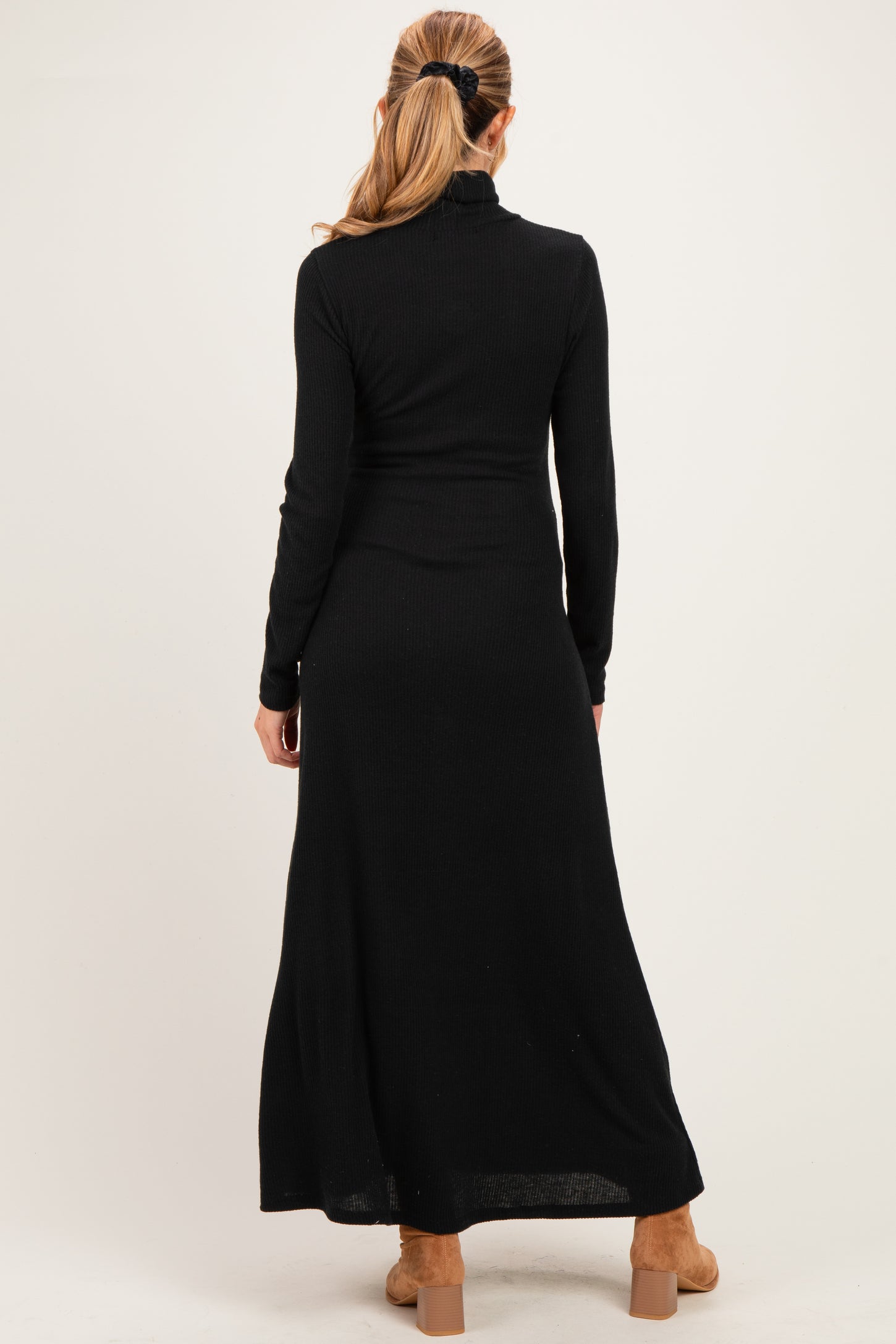 woman wearing a black long sleeve ribbed maternity dress, view from the back