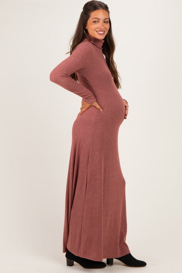 woman wearing a rust long sleeve ribbed maxi dress with a fitted bodice and a flowing skirt, showing her baby bump